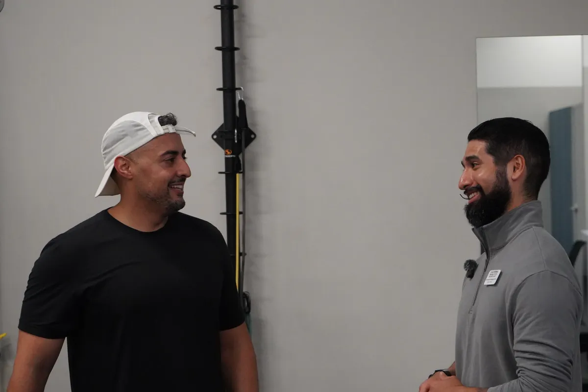 Dr. Rodriguez and a client smiling during a conversation about training goals