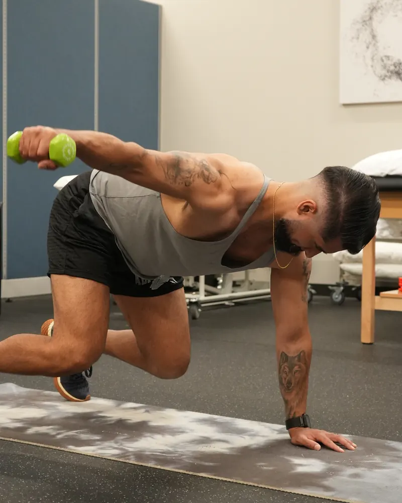 Dr. Rodriguez performing a bird dog with a light dumbbell reach
