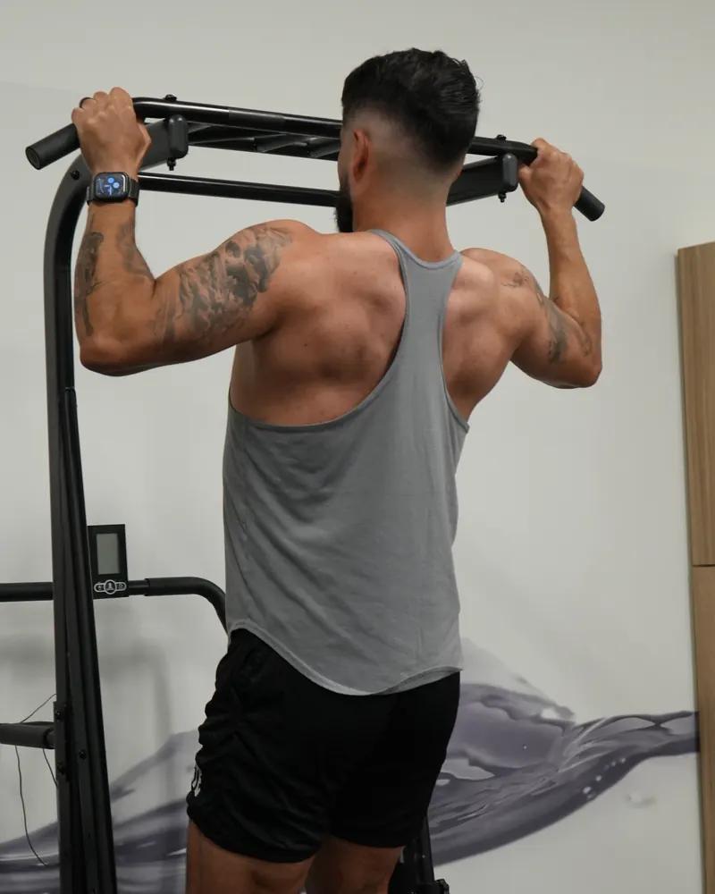 Dr. Rodriguez gripping a pull-up bar, viewed from behind
