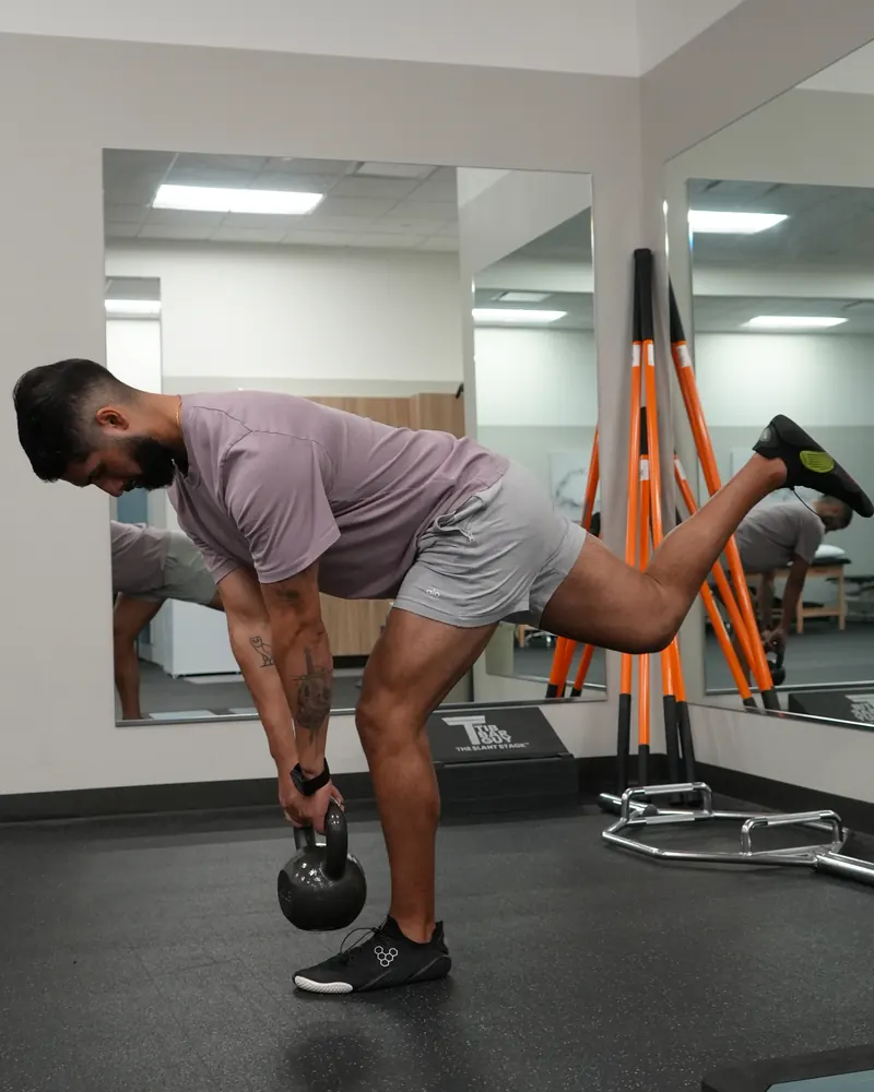 Dr. Rodriguez performing a single-leg Romanian deadlift with a kettlebell