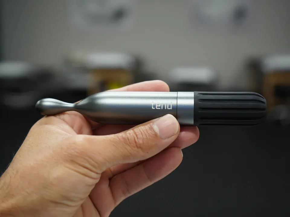 TEND focal vibration therapy pen held in hand